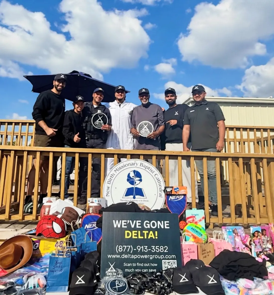 Delta Power Group team at a community toy drive with a We have gone Delta poster